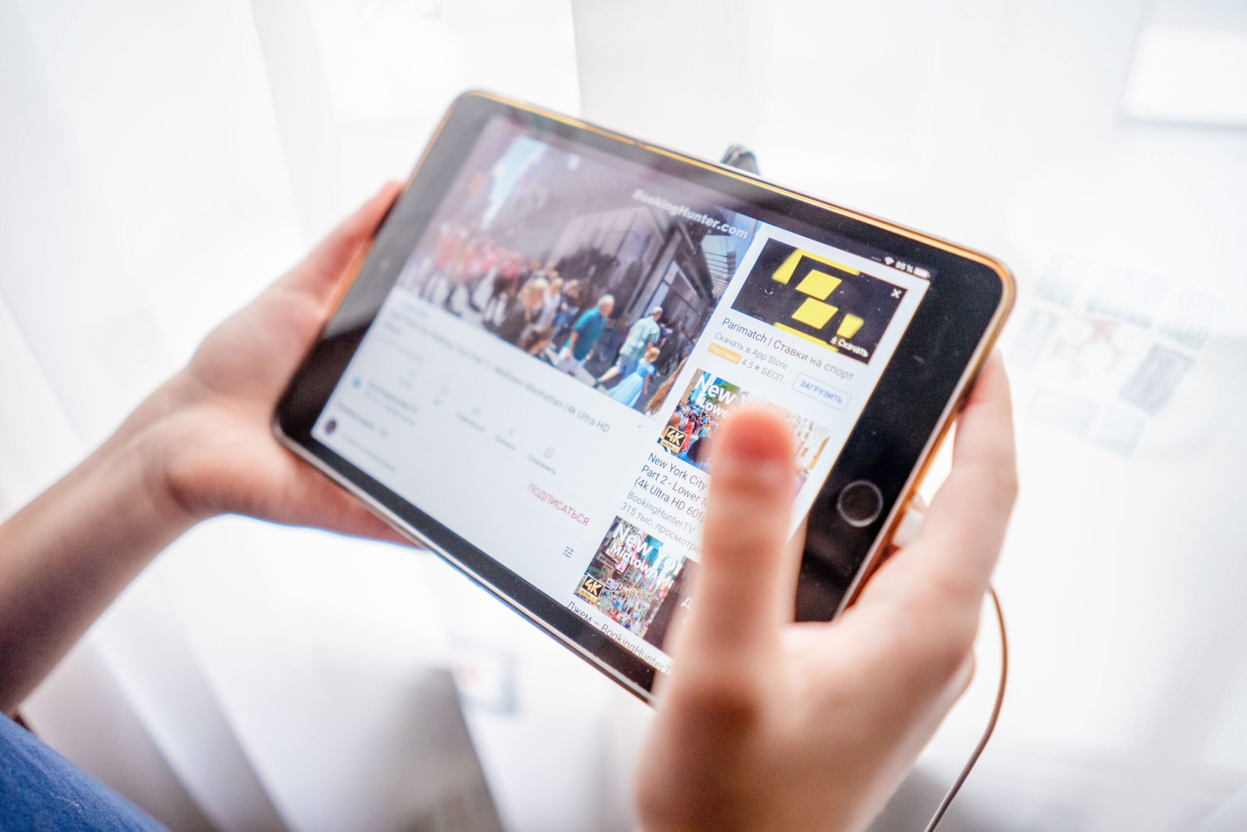 Home Close-up of hands holding a tablet device browsing online content indoors.