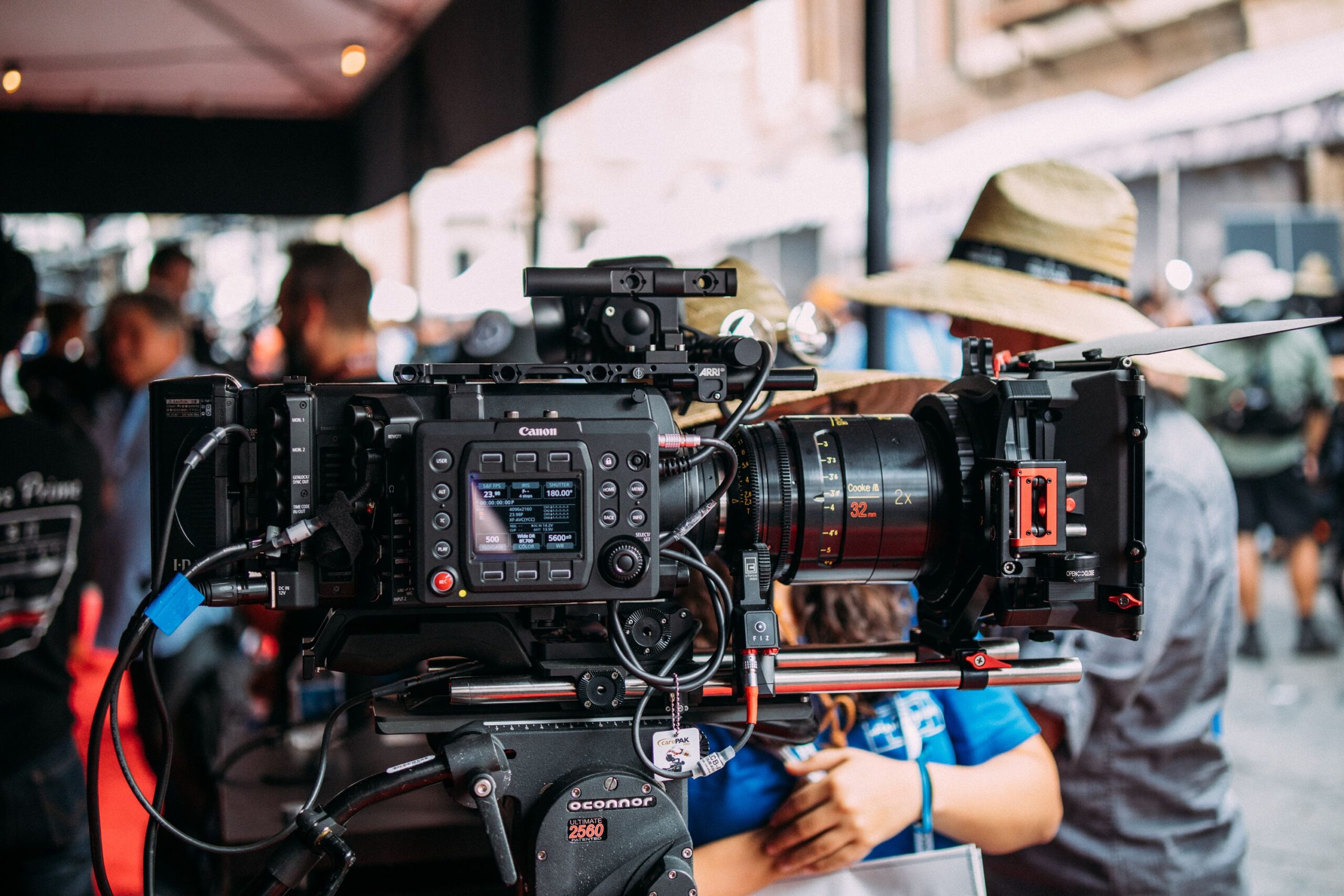 Home Close-up of a professional video camera setup at an outdoor event focusing on filmmaking equipment.
